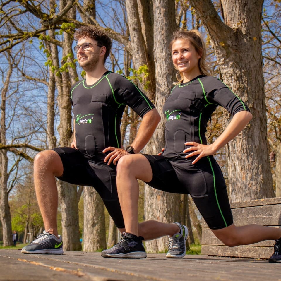 A couple stretching together outdoor with EMS suit